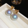 Macro shot of gold heart-shaped studs with textured metal and iridescent pearls - Gold Textured Heart Grey Aurora Pearl