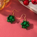 Detailed macro view of forest green ribbon bow earrings with gold hooks on red background - D1306 (Green Flower Ball)