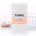 Soft white coral fleece bath towel rolled with orange label in a minimalist setting - 70*140cm / Milky White (Wrapped)