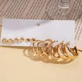 Primo piano del set da 12 orecchini dorati con disegni a cuore e a cerchio su cartoncino - Set da 12 pezzi / Oro
