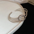 Detailed macro view of silver twisted metal bangles on white ceramic edge - Silver 3-Layer Braided Ring Style