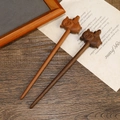 Macro shot of two sandalwood hair sticks with carved pig motifs in light and dark brown - Pig Carved Style (F2023807)
