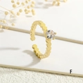 Detail-Makroaufnahme eines goldenen Wellenrings mit Zirkonia-Stein und offenem Design - Weiß (RG0363-F)