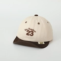 Dettaglio del ricamo Numero 23 sul cappellino bicolore per bambini con visiera morbida - 50cm (1-3 Anni) / Bianco Riso (Numero 23)