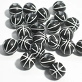 Macro shot of 50 black and white basketball-shaped acrylic spacer beads for DIY jewelry - 12mm Basketball Black Background White Line