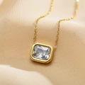Macro shot of an emerald-cut zircon pendant on a gold stainless steel chain necklace - White