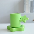 Green ceramic mug with unique star-shaped handle and matching saucer on white desk - Star Cup & Saucer - Green