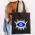 Black canvas tote bag featuring a large colorful Greek Evil Eye graffiti print - Design E-Radiant Totem-Black