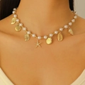 Bohemian pearl necklace with gold seashells and starfish charms on a model's neck - Gold Ocean Element Pearl Necklace (WG-0134)