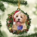 Close-up of a golden dog in a Christmas wreath ornament hanging on a pine tree branch - Style 19