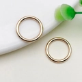 Paar minimalistische gladde KC goudlegering ringen op een wit keramisch bordje - Cirkel link