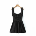 Detail of black satin slip dress showing elegant shoulder bow ties on a wooden hanger - S / Black