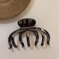 Detailansicht einer hochwertigen schwarzen Metall-Haarklammer auf einem weißen Schreibtisch - Gunmetal-Schwarz