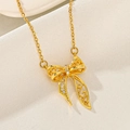 Close-up of golden bow pendant with hollow brushed texture and sparkling zircon stones - Hollow Bowknot (F412)