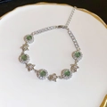 Bracelet argenté avec pierres vertes et pendentifs en forme d'étoile sur porcelaine blanche - Bracelet Étoile de Mer Fleur Ronde en Zircone (21)
