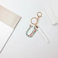 Floral letter U keychain with red flower pattern, green border, and white tassel accent - Letter U (With Tassel)
