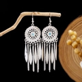 Macro shot of silver bohemian drop earrings with blue beads and leaf tassels on a wood branch - Dreamcatcher Sky Blue Bead Feather Tassel Style (E2871-15)