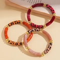 Detailed macro view of acrylic leopard print tube bracelets with gold beads in 3-piece set - Three-Piece Set / Red Series (HB4546-2)