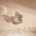 Close-up of a silver five-petal flower ear clip with metallic texture on stone - Clip Earring - Silver Flower