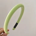 Close-up of a light green fabric headband featuring a stitched Hand Made label - Yellow-Green