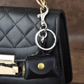 Mini-Geldbörse aus schwarzem Leder mit goldenem Druckknopf an einer Handtasche - Schwarz