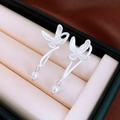 Detailed close-up of matte silver flower earrings with pearl accents on white satin - Silver Flower (Silver Pin)