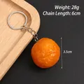 Realistischer Orangenmodell-Schlüsselanhänger aus PVC mit silbernem Metallring auf Schwarz - Süßkartoffelball (Schlüsselanhänger)