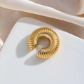 Minimalistisches goldenes Ohrklemm-Modell mit vertikal gerippter Textur auf weißem Stand - Einzelstück / Gold