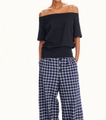 Detail of off-shoulder black T-shirt and blue plaid wide-leg pants on a fashion model - S / Black