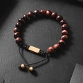 Detail of adjustable tiger eye beaded bracelet with brushed gold metal plate on black texture - Red Tiger Eye Braided