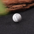 Natural 16mm white marble crystal sphere with grey textures on black textured background - White Turquoise