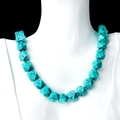 Faceted turquoise stone necklace with knotted details on a white jewelry mannequin - Blue Turquoise (Synthetic)