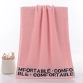 Pink cotton towel with comfortable embroidery and soft looped texture in hanging display - Pink With Letters