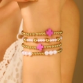 Dettaglio del set di quattro bracciali con perle bianche e ciondoli a croce rosa - Stile Croce Viola (A-1076)