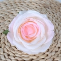 Pink and white silk artificial rose head with rich layers on a woven straw mat - Nude Pink