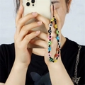 Detail einer bunten Evil Eye Perlen-Handykette, die an einer Smartphone-Hülle hängt - Mehrfarbige Böser Blick Runde Perlen