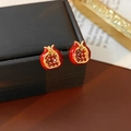 Primer plano de pendientes de granada vintage con esmalte rojo y base de metal dorado - Pendientes de botón Granada