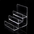 Three-tier transparent acrylic display stand for wallets and phones on black background - Triple Layer / Clear