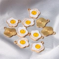 Macro view of poached egg charm back side featuring gold-plated radial texture - Fried Egg