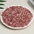 Polished bulk rose quartz crystal chips displayed on a round white ceramic tray - Rosewood Grain (5-7mm) 100g