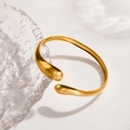 Elegant gold-tone open cuff bracelet featuring a unique teardrop design in stainless steel - Gold Streamline Teardrop