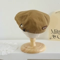 Detalle de gorra plana infantil caqui con logotipo BRUHT bordado sobre un soporte de madera - 52-54cm (3-8 Años) / Etiqueta BRU - Caqui