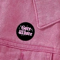 Gore Whore text badge in pink on a black circular brooch pinned to a denim jacket - Bloody Bad Word Design (XZ8909)