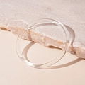 Macro shot of clear acrylic circular bracelet resting on a textured beige stone base - Transparent Thin Style (8#)