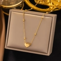 Detail view of heart pendant necklace with gold beads on display in a luxury jewelry box - Heart Pendant (AH205) / Gold