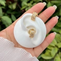 Orecchini a onde placcati oro 18k con zirconi indossati su un modello di orecchio - 1-Stile Pavé a Onda