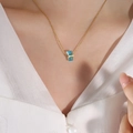 Gold-tone titanium necklace featuring a rectangular blue gemstone pendant on a model - Dark Blue/December