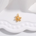 Elegant gold snowflake pendant with sparkling zircons on white ceramic tray - Gold