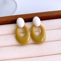 Macro shot of stylish white and mustard yellow acrylic hollow oval earrings on beige tray - White & Mustard Yellow Style (Silver Pin - Green)