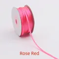 Detailed view of 3mm rose red double-sided satin ribbon roll on a white spool - 3mm/50 Yards / Rose Red